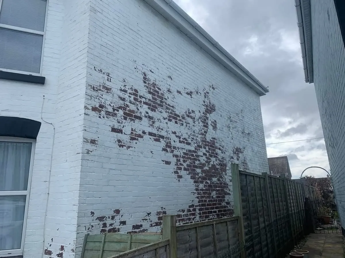 Peeling paint on a brick wall before redecoration in Camborne